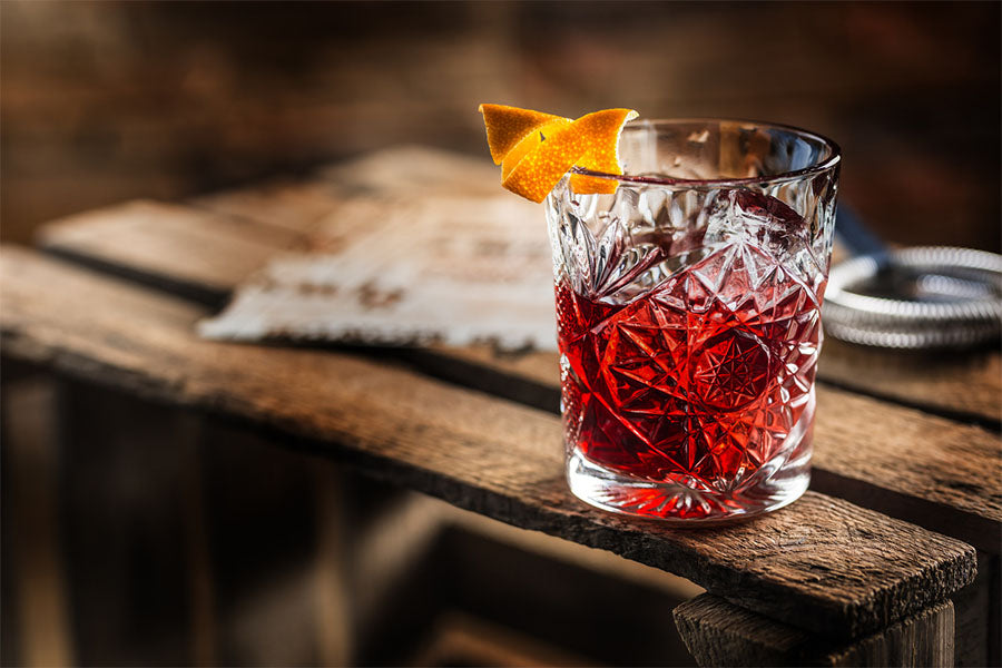 a tea mocktail sits in a glass on a wooden table