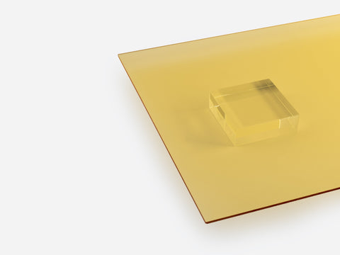 A yellow transparent acrylic sheet and block on white background