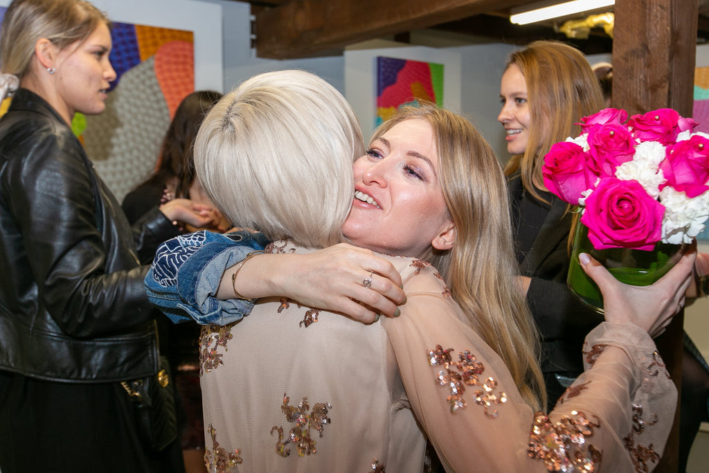 Photograph of two women hugging at Voss Gallery, San Francisco during Valentine's Day.