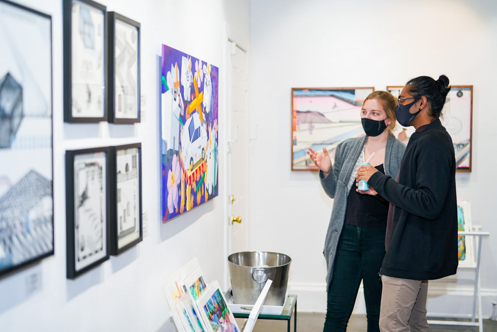 Photograph of two people discussing in front of artwork during Tim Irani and Neddie Bakula's "Double Vision" duo exhibition post analog surrealist VIP Collectors Event at Voss Gallery, San Francisco, February 2021.