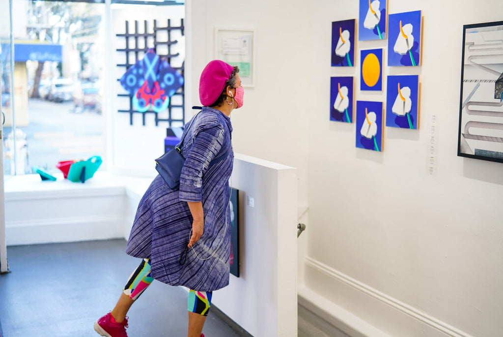 Photograph of a woman viewing artwork during Tim Irani and Neddie Bakula's "Double Vision" duo exhibition post analog surrealist VIP Collectors Event at Voss Gallery, San Francisco, February 2021.