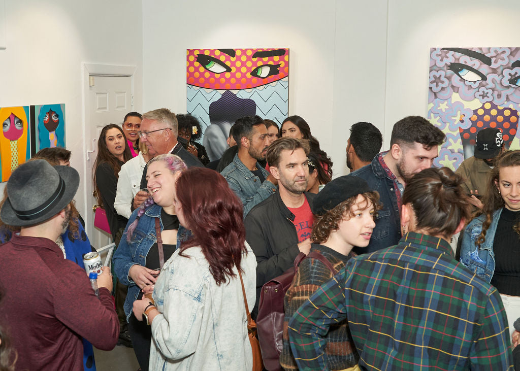 Photograph of people talking and viewing artwork during Ernie Steiner's "Figuratively Speaking" solo exhibition Opening Reception at Voss Gallery, San Francisco, April 22, 2022.