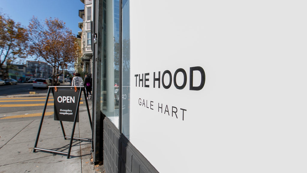 Install image from Gale Hart's "The Hood" solo exhibition at Voss Gallery, San Francisco in November 2019. Photograph of the outside of the gallery with an open sign and exhibition vinyl text.