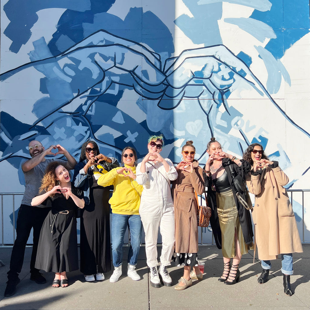 The Tracy Piper with Voss Gallery and friends standing in front of the artist's mural at San Francisco's iconic Ferry Building.