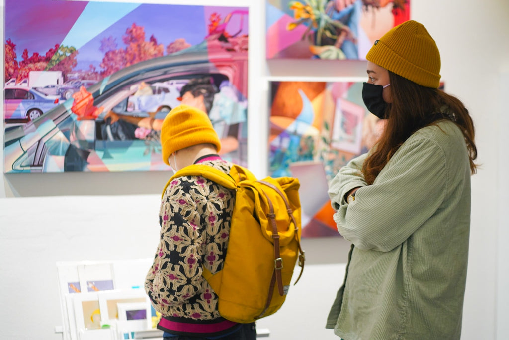 Photograph of two people during Ian Robertson-Salt's "Nine to Five" spotlight exhibition Opening Reception of New Contemporary paintings at Voss Gallery in San Francisco, January 2022.