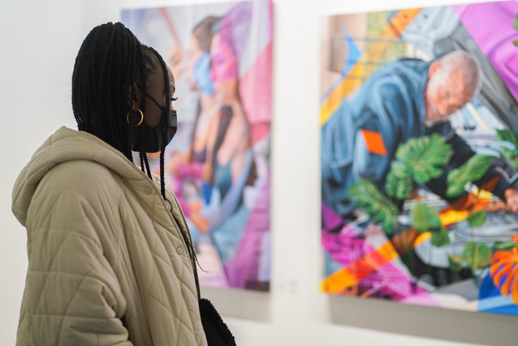 Photograph of black woman viewing artwork during Ian Robertson-Salt's "Nine to Five" spotlight exhibition Opening Reception of New Contemporary paintings at Voss Gallery in San Francisco, January 2022.