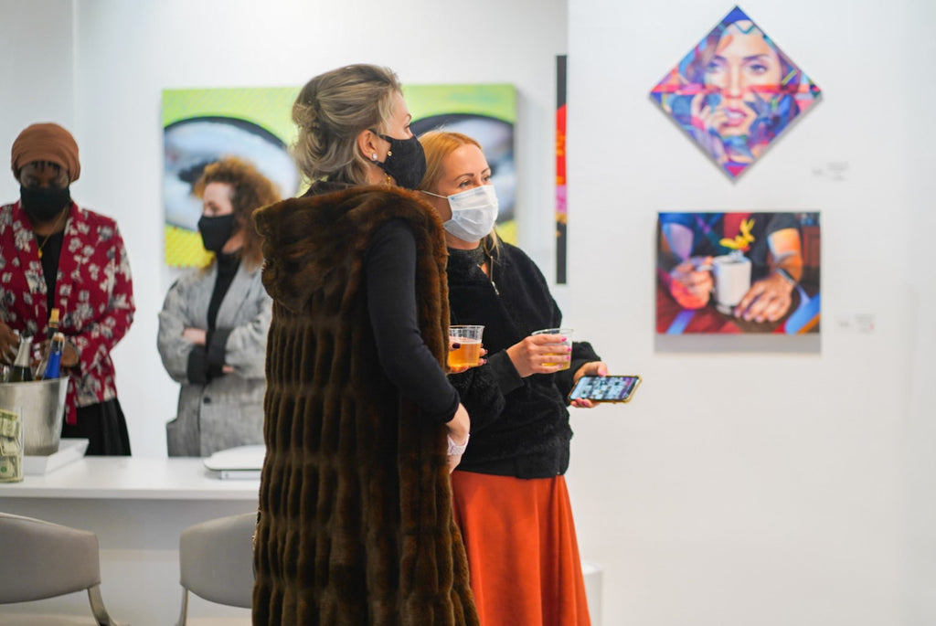 Photograph of two women viewing artwork during Ian Robertson-Salt's "Nine to Five" spotlight exhibition Opening Reception of New Contemporary paintings at Voss Gallery in San Francisco, January 2022.