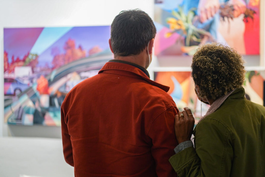 Photograph of a couple viewing artwork during Ian Robertson-Salt's "Nine to Five" spotlight exhibition Opening Reception of New Contemporary paintings at Voss Gallery in San Francisco, January 2022.