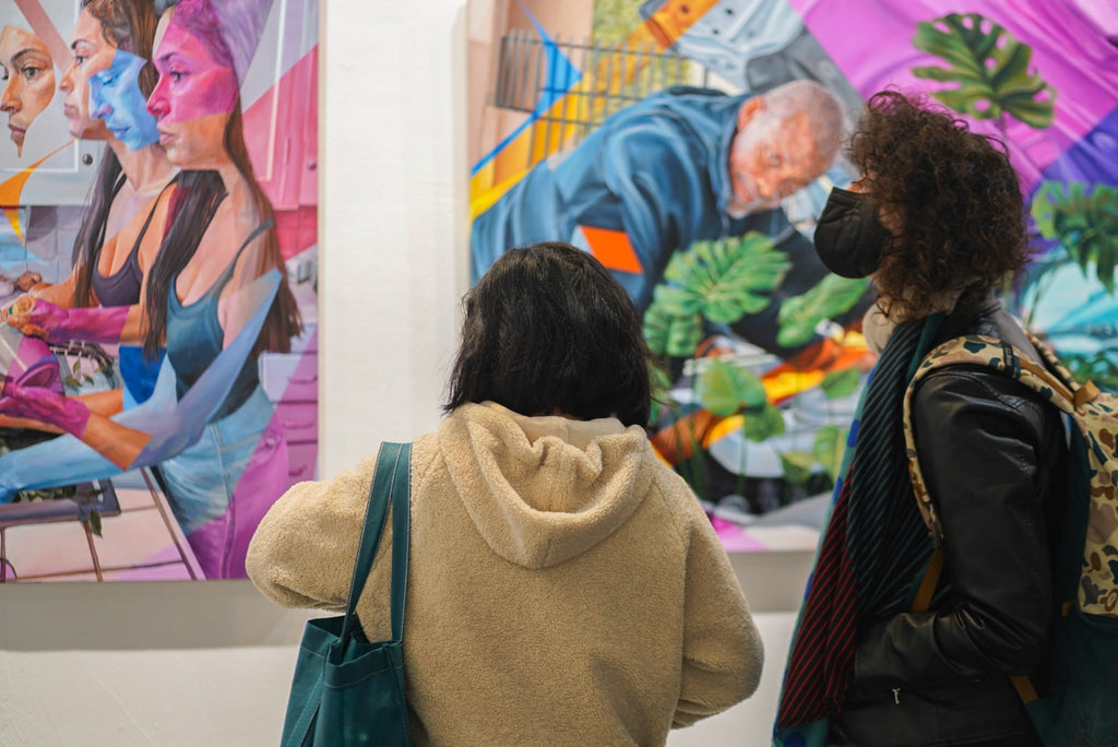 Photograph of two people viewing paintings during Ian Robertson-Salt's "Nine to Five" spotlight exhibition Opening Reception of New Contemporary paintings at Voss Gallery in San Francisco, January 2022.