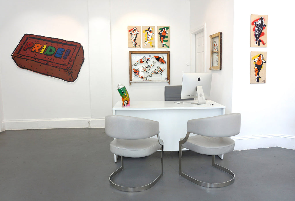 Photograph of a reception desk with chairs and artwork during Jeremy Novy's "The First Pride was a Riot" solo exhibition at Voss Gallery, San Francisco, June - July 2020.