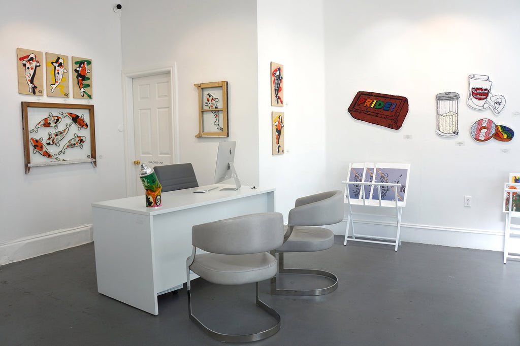 Photograph of a reception desk with chairs and artwork during Jeremy Novy's "The First Pride was a Riot" solo exhibition at Voss Gallery, San Francisco, June - July 2020.