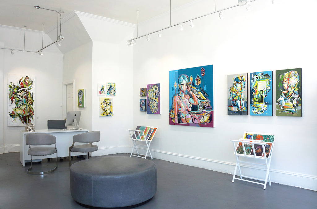 Photograph of paintings, a desk and chairs at Voss Gallery in San Francisco during John Osgood's "In Plain Sight" solo exhibition, May-June 2020.