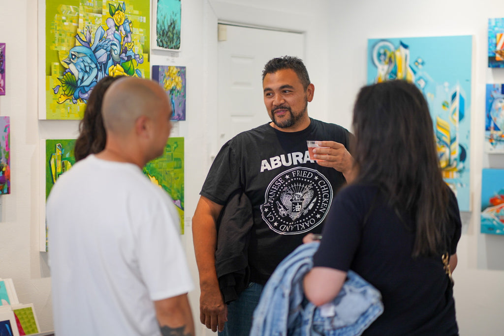 Photograph of attendees talking during the "Reflect.Renew.Rebirth" duo exhibition opening reception at Voss Gallery in San Francisco, July 21, 2023.