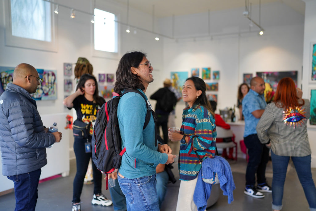 Photograph of people viewing artwork during the "Reflect.Renew.Rebirth" duo exhibition opening reception at Voss Gallery in San Francisco, July 21, 2023.