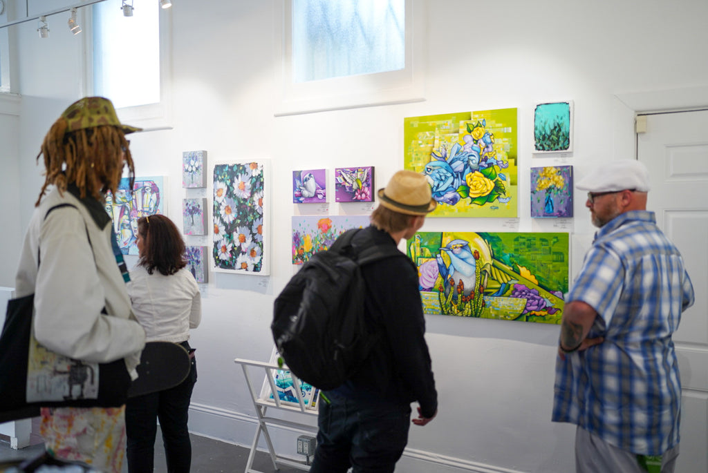 Photograph of gallery visitors viewing artwork during the "Reflect.Renew.Rebirth" duo exhibition opening reception at Voss Gallery in San Francisco, July 21, 2023.