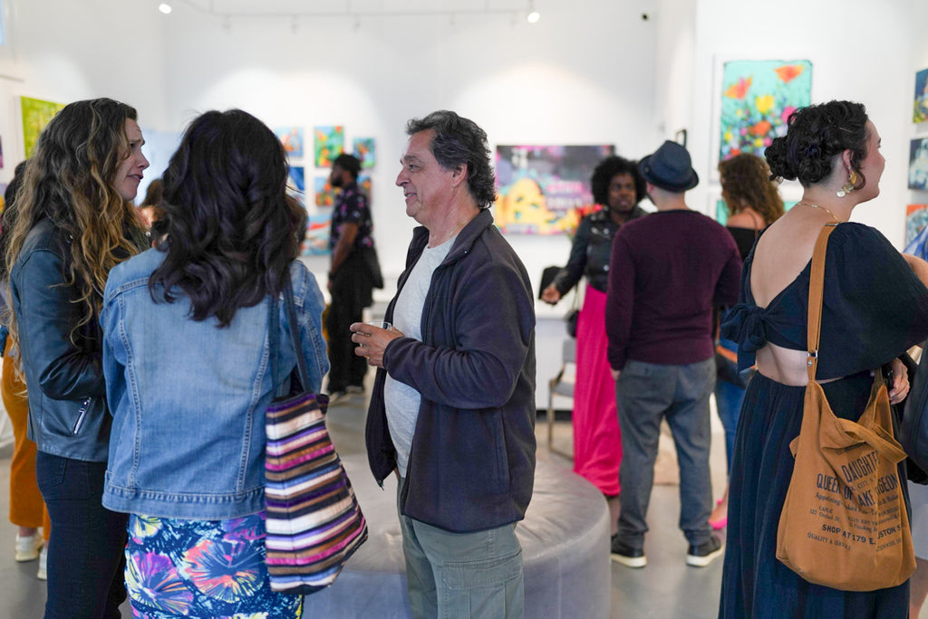 Photograph of people talking and viewing artwork during the "Reflect.Renew.Rebirth" duo exhibition opening reception at Voss Gallery in San Francisco, July 21, 2023.