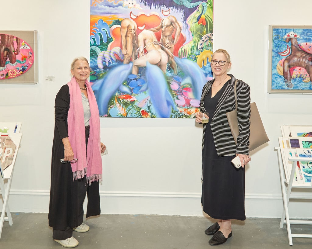 Photograph of two blonde women standing beside an artwork during the Opening Reception of Justyna Kisielewicz's "Entangled Stories" solo exhibition at Voss Gallery, San Francisco, September 9, 2022.