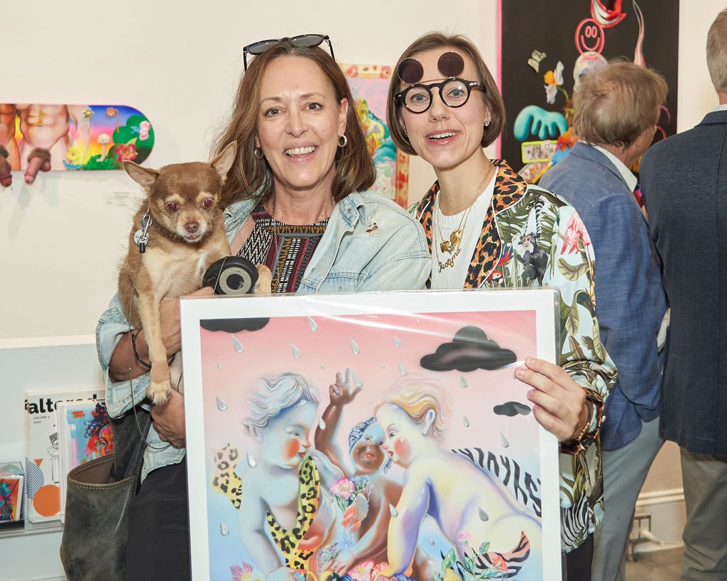 Photograph of two women holding a dog and a fine art print during the Opening Reception of Justyna Kisielewicz's "Entangled Stories" solo exhibition at Voss Gallery, San Francisco, September 9, 2022.