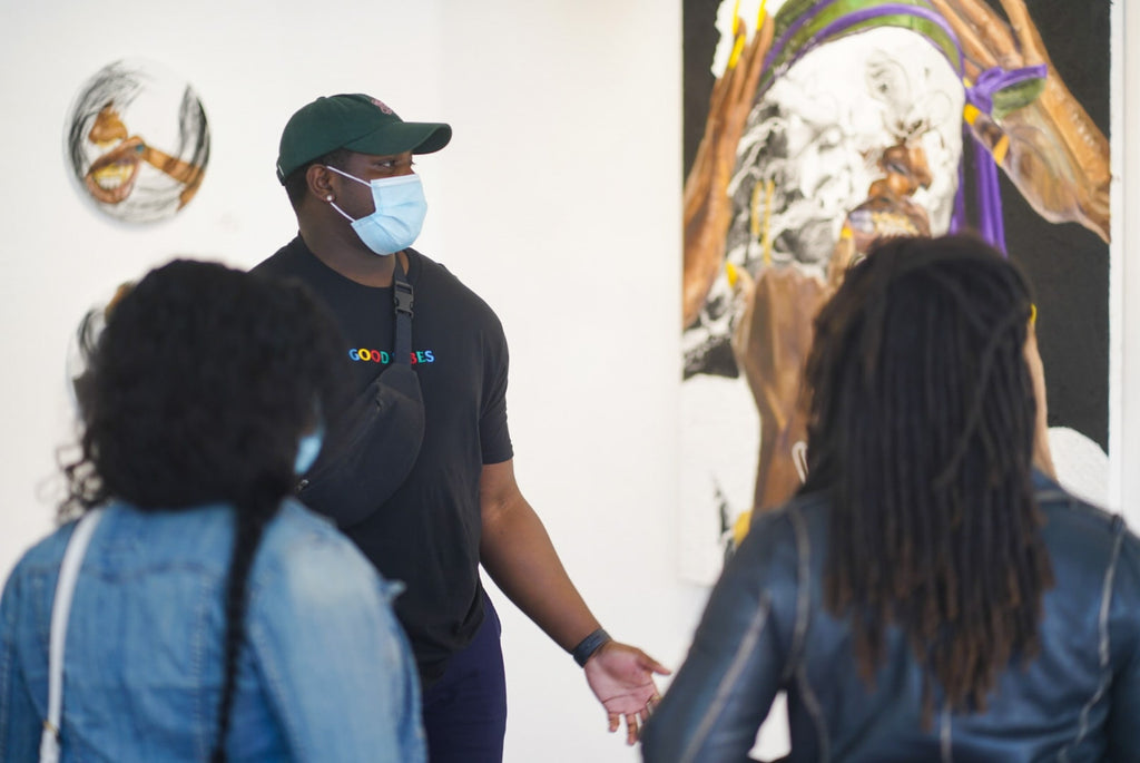 Photograph of artist talking to people during Khari Turner's "Hella Water" solo exhibition Opening Reception at Voss Gallery, San Francisco, May 21, 2021.