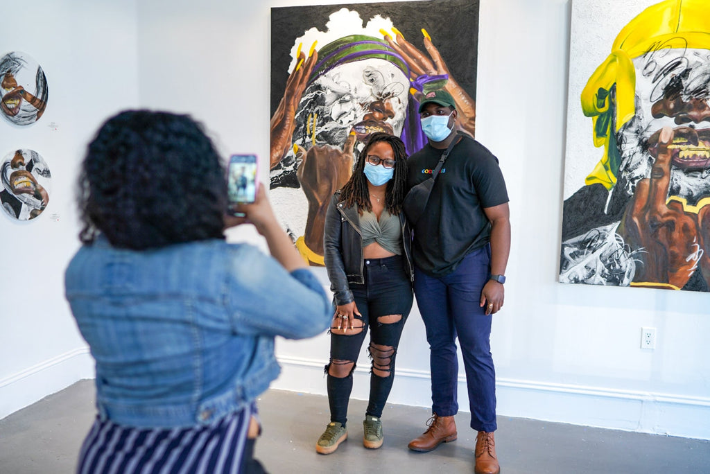 Photograph of two people being photographed during Khari Turner's "Hella Water" solo exhibition Opening Reception at Voss Gallery, San Francisco, May 21, 2021.