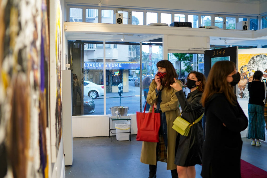 Photograph of women looking at artwork during Khari Turner's "Hella Water" solo exhibition Opening Reception at Voss Gallery, San Francisco, May 21, 2021.