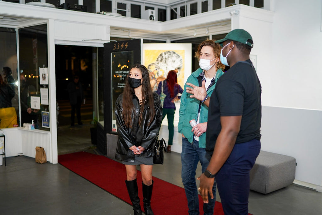 Photograph of artist talking to guests during Khari Turner's "Hella Water" solo exhibition Opening Reception at Voss Gallery, San Francisco, May 21, 2021.