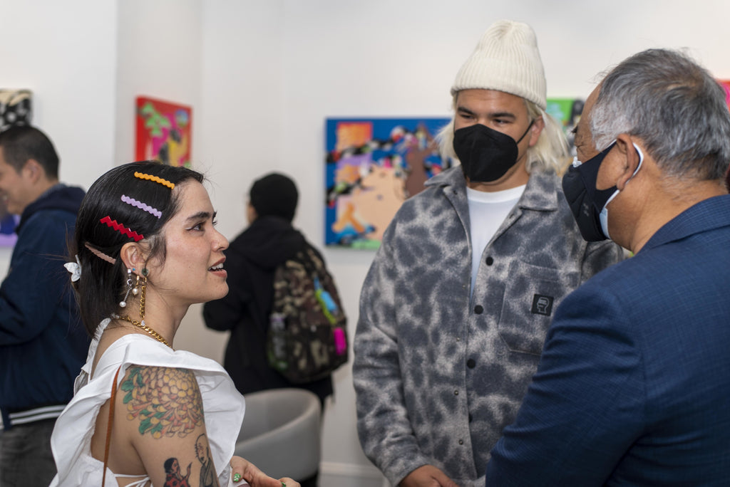 Photograph of artist talking to two men during Maya Fuji's "Kami" solo exhibition Opening Reception at Voss Gallery in San Francisco, May 27, 2022.