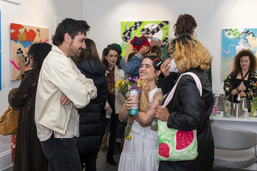 Photograph of artist laughing and discussing with guests during Maya Fuji's "Kami" solo exhibition Opening Reception at Voss Gallery in San Francisco, May 27, 2022.