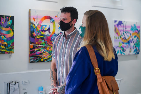Photograph of two people during Joshua Nissen King's "Fruit of Another"solo exhibition Meet the Artist Event at Voss Gallery, San Francisco, September 12, 2020.