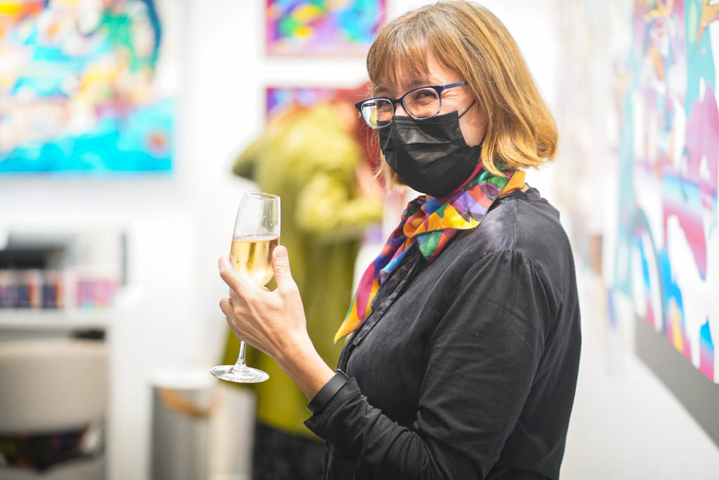 Photograph of artist, Jennifer Banzaca holding a glass of wine during Jennifer Banzaca & Joshua Nissen King's "Mirage" duo exhibition Opening Reception at Voss Gallery, October 22, 2021.