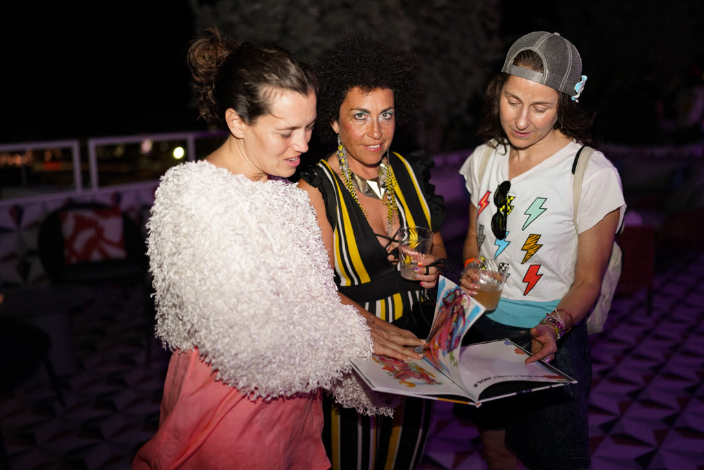 Three Art Basel Happy Hour attendees reading The Tracy Piper's book "Worthy" during our pop-up show at Moxy Hotel in South Beach during Miami Art Week.