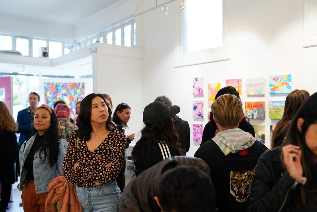 Photograph of people atending the Opening Reception of the Postcards from Paradise Juried Group Exhibition at Voss Gallery in San Francisco, May 26, 2023.