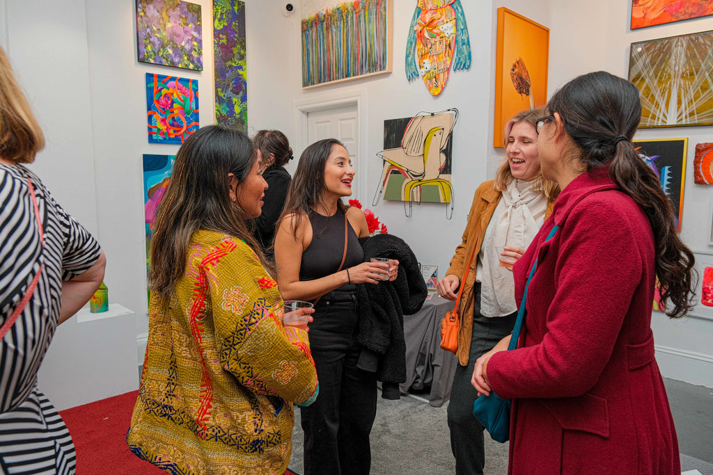 Photograph of a group of women talking during the opening night of the "Refusés of the Bay" Group Exhibition at Voss Gallery, San Francisco, September 29, 2023.