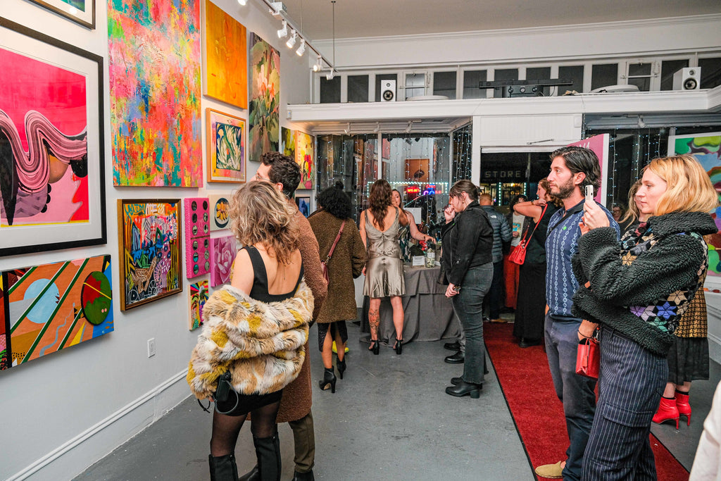 Photograph of people viewing vibrant artwork during the opening night of the "Refusés of the Bay" Group Exhibition at Voss Gallery, San Francisco, September 29, 2023.