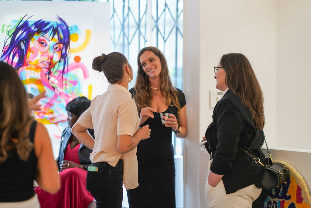Photograph of three ladies talking to each other during the opening reception of The Tracy Piper's "All the Feels" solo exhibition at Voss Gallery, San Francisco, August 25, 2023.