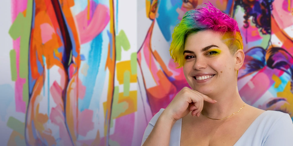 Portrait of contemporary figurative artist, The Tracy Piper standing in front of her paintings at Voss Gallery in San Francisco, CA.