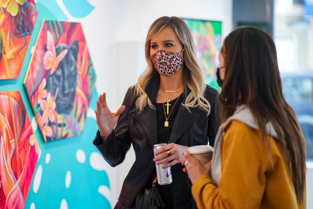 Photograph of a woman talking to another woman during the Paradise group exhibition VIP Collectors Event at Voss Gallery, San Francisco, April 2021.