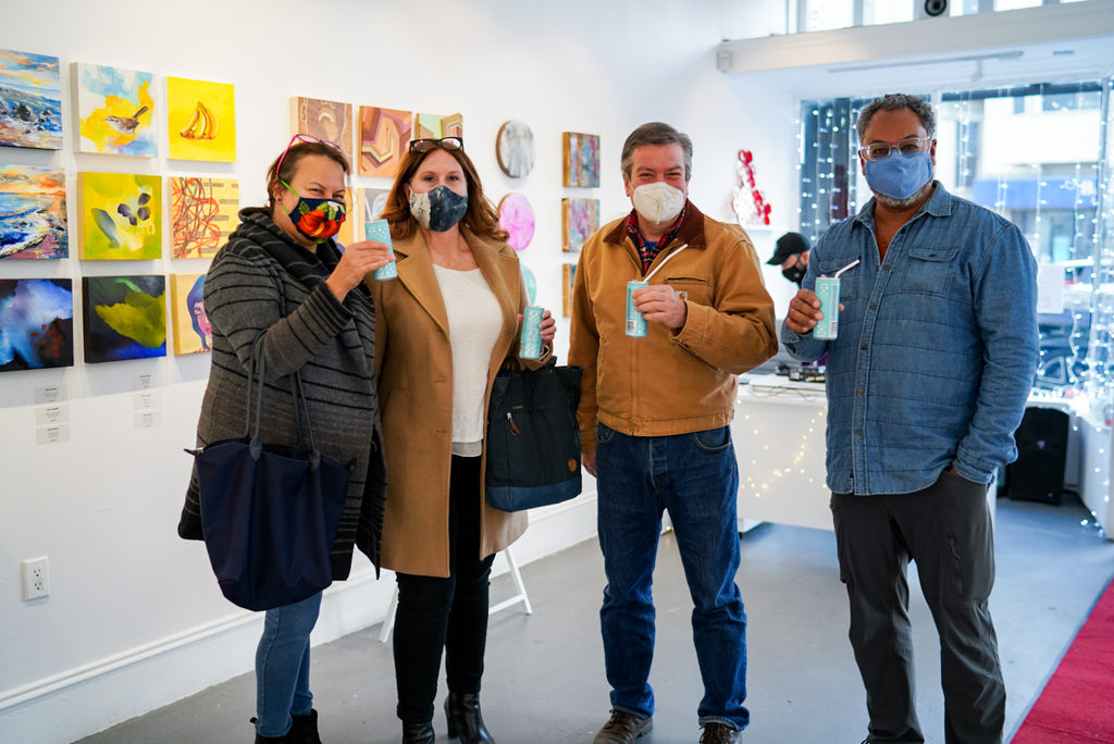 Photograph of four people holding canned drinks during the "It's BASL, Baby!" group exhibition VIP Young Collectors Event at Voss Gallery, San Francisco, December 4, 2020.