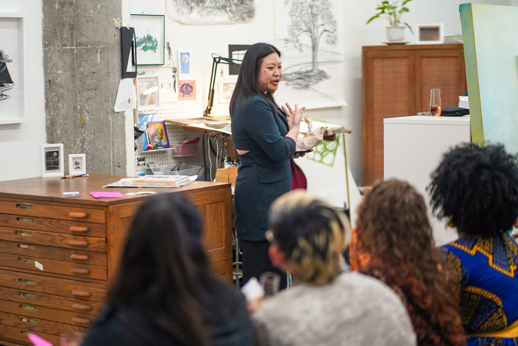Photograph of a female artist lecturing during the 'Art Unveiled: Collectors Mixer' at Voss Collector Club's visit to 1890 Bryant Studios, San Francisco, on March 10th, 2024.