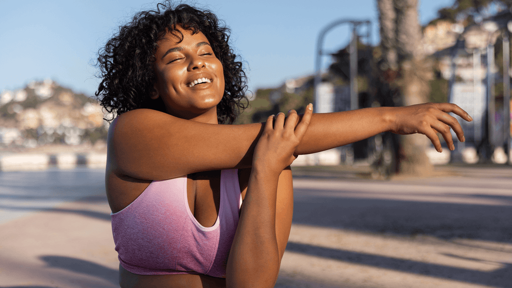 mulher morena com cabelos em caracóis a fazer alongamento