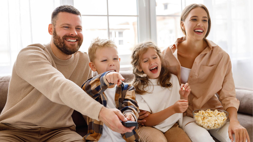Día del Padre: Familia feliz viendo películas en casa con palomitas de maíz