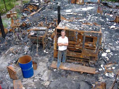 Terry Warburton standing in burned remains of factory 2005