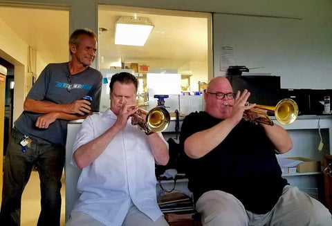 Terry Warburton listens as Roger Ingram and Dan Miller play in the Warburton Factory Offices, July 2016