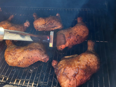 Basting chicken on the grill with additional maple glaze.