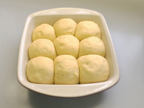 Rolls that have risen and are ready to be baked in the oven.