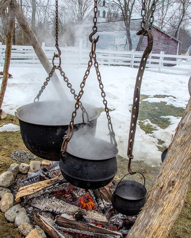 Large cast iron pot being used to reduce sugar maple sap to maple