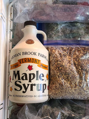 A plastic container of maple syrup stored in the freezer to preserve the freshness.