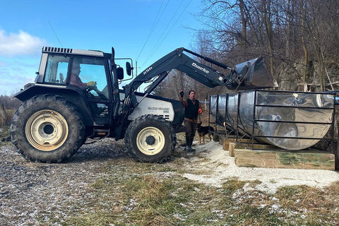 Daniel and Levon Fortin using a tractor to move a sap tank out to pumphouse one.