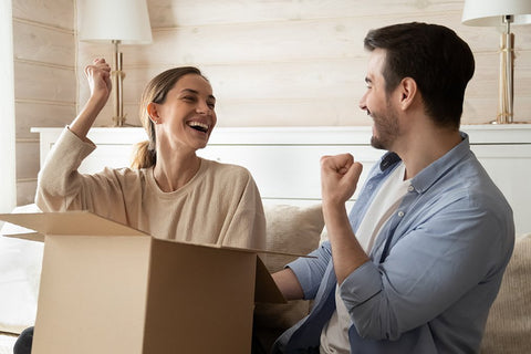 A very happy couple opening their box of wedding favors and celebrating.