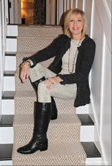 A woman sitting on  stairs wearing black boots
